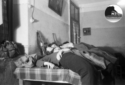 9 Partigiani stesi a riposare sui tavoli - fucili appoggiati al muro..jpg