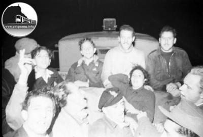 7 Partigiani seduti sul cassone posteriore di un camion..jpg