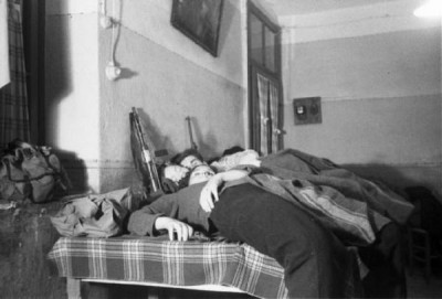 Partigiani stesi a riposare sui tavoli - fucili appoggiati al muro..jpg